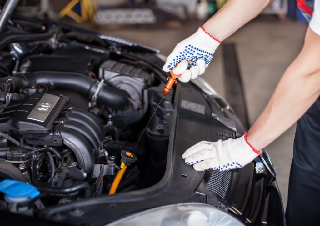 Mechanic checking engine oil - Car Service Ely